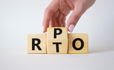 RPO vs RTO symbol. Businessman hand turns wooden cubes and changes the word RTO to RPO. Beautiful white background. business concept. Copy space
