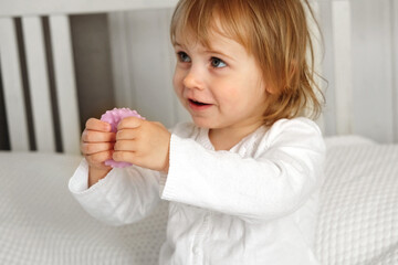 Cute baby girl playing tactile knobby balls. Young child hand plays sensory massage ball. Enhance the cognitive, physical process. Brain development. Support for Children with ADHD, autism, fidgeting