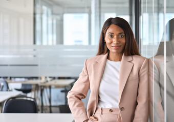 Smiling elegant confident young professional business woman, female proud leader, smart businesswoman lawyer or company manager executive looking at camera standing in office, portrait.