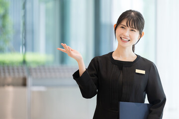 Image of a smiling Japanese woman in the hospitality industry who works as a receptionist at a...