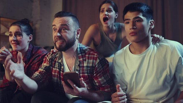 Online betting and winning. Young people, friends sitting at home and watching football match on tv, sport fans cheering up favourite team. Concept of leisure time, sport fans, friendship, emotions