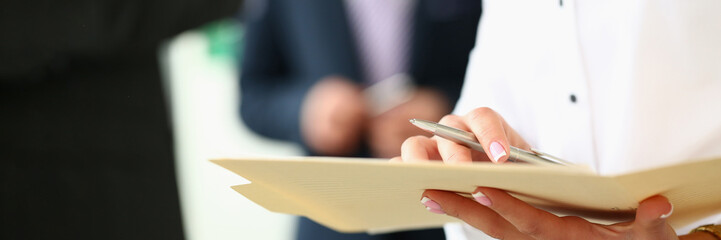 Women hands holding pen and documents in background business people. Business agreements and joint partnerships