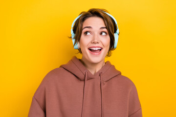 Photo of astonished impressed woman short hairdo wear brown hoodie headphones staring at empty...