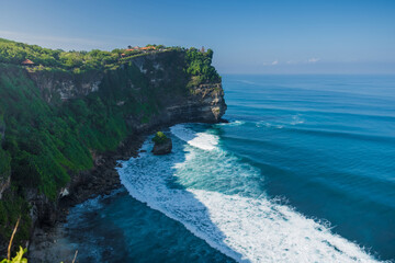 Scenic rocky cliff and ocean in Uluwatu, Bali. Popular tourist place with balinese temple