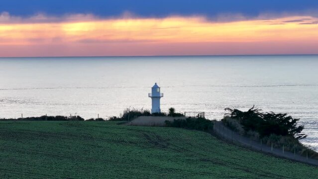 Colourful sky over lighthouse tower at Jack's Lighthouse, Timaru, New Zealand. Coastal during sunrise.