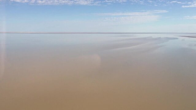 Flying in a plane over the water in Lake Eyre, South Australia