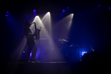 stage with stage lights and silhouette of the person playing saxophone 