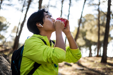 A Korean man is hiking in the middle of Mt. The boy is sitting drinking a cup of coffee while...