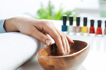 Closeup female hands in wooden bowl with water