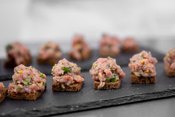 Chef cooks of French restaurant prepares steak tartare from fresh meat