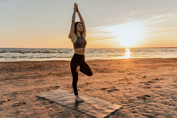 Calm and harmony.  Balance and meditation woman training yoga asana outdoors near the lake. The...