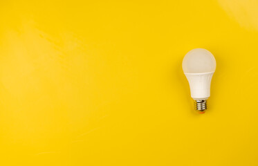 White light bulb on bright yellow background. Energy saving light bulb on yellow background with free space for text. Electrical equipment. Idea, creative, bright, brainstorming and smart concept.
