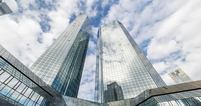 Frankfurt skyline in 4k. Time lapse of skyscraper. Modern financial building look up with clouds moving and reflection. 