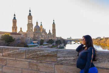 Pregnant Latina woman looking at the Pilar Cathedral