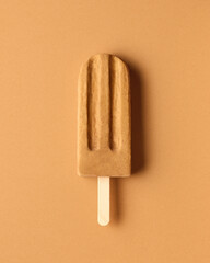 Caramel peanut popsicle on brown background