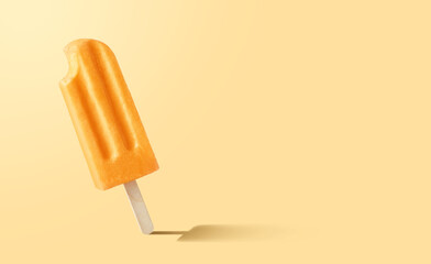 Bitten orange fruit popsicle on yellow background
