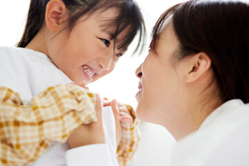 リビングにて向かい合う幸せそうな日本人の母親と子供