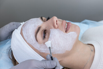 A woman receiving facial care from a cosmetologist at a spa,