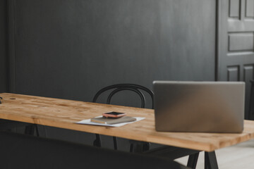 Administrator's workplace with a laptop against a dark wall. Interior Design