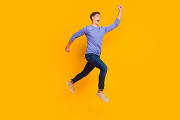 Full length side profile body size photo of jumping run fast man rushing wearing casual jeans shirt isolated on yellow background