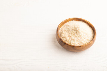 Powdered milk and buckwheat baby food mix, on white wooden, side view, copy space