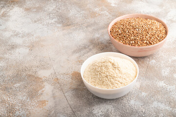 Powdered milk and buckwheat baby food mix, on brown concrete, side view, copy space