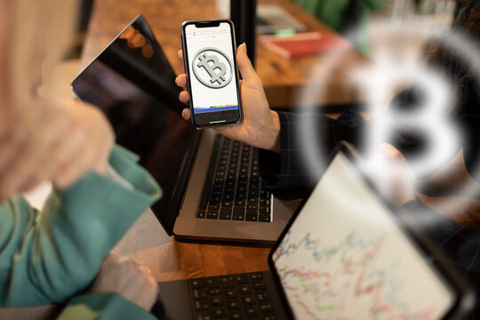Crypto currency traders trading bitcoin using laptops and phone