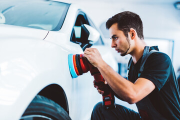 Car detailing and polishing done by service man in workshop