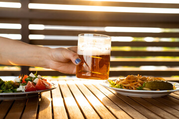 Female drinking lager beer at summer terrace