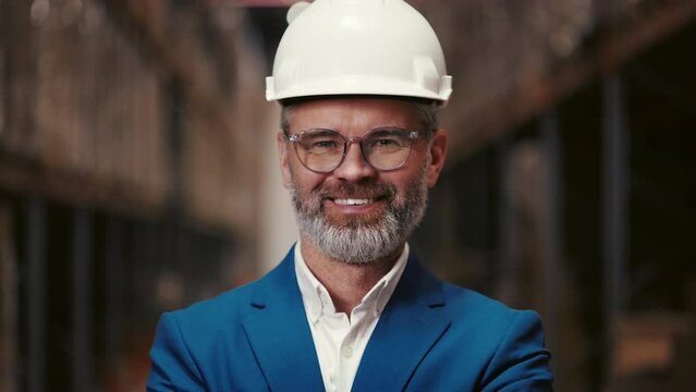 Portrait of Positive Mature Man Industrial Boss Smiling, Looking at Camera, Wearing Suit and Glasses. Businessman Owner Standing in the Distribution Centre