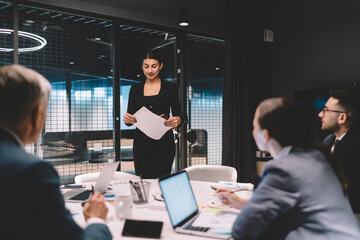 Female partner having presentation with employees in workspace