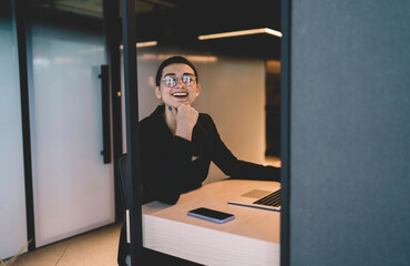 Fototapeta na wymiar Cheerful woman at desk in modern office space