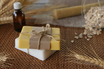 Handmade soap bars, wax candle, oil essential and oats. Natural ingredients for homemade facial and body mask or scrub. Healthy skin care. SPA concept. Selective focus. Side view.