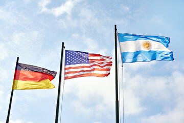 Germany, USA and Argentina flags on sky