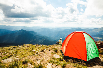 Woman with a tent on top of a mountain © phpetrunina14
