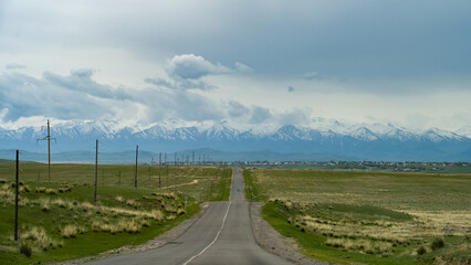 Fototapeta na wymiar the road through the steppe to the mountains. cloudy weather in the mountains
