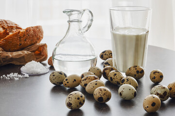 Group of quail eggs, bread, salt, glass of a milk. Shallow depth of field