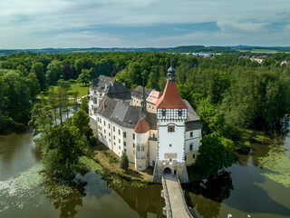 Fototapeta na wymiar Aerial view of Blatna medieval water castle with towers, turrets, plus extensive grounds in Bohemia