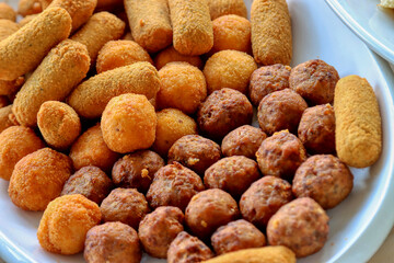 Plate of fried food. Meatballs, potato croquettes, arancini