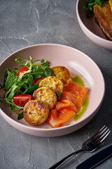 Ukrainian salty syrnyky with lightly salted salmon and sun-dried tomatoes served with mixed salad. Cheese pancake