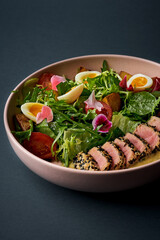 Nicoise salad with tuna, tomatoes and egg in a plate