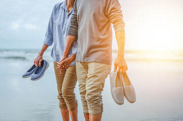 Plan life insurance of happy retirement concepts. Senior couples walking carrying shoes on the...