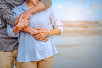 Plan life insurance of happy retirement concepts. Portrait of Senior couple embrace on the beach sunset in evening.