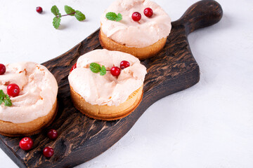 Small meringue pie on shortcrust pastry served on wooden board. Portion sized dessert