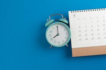 close up of calendar and alarm clock on the blue table background, planning for business meeting or...