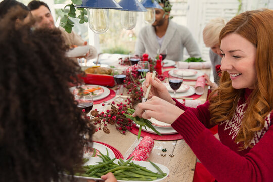 Woman serving green beans at Christmas dinner - Powered by Adobe