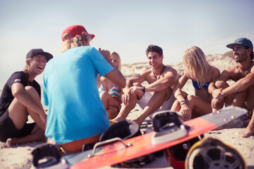 Friends learning kiteboarding on sunny beach - obrazy, fototapety, plakaty