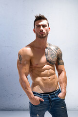 Handsome shirtless athletic man with arms crossed on muscular chest
