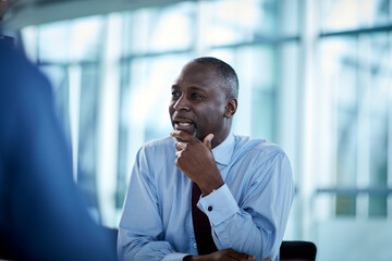 Businessman listening looking away in meeting