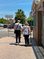 Fototapeta na wymiar Couple walking in the street. Sunny day, people, walk, background, park, together, old